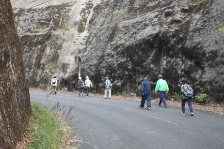岩壁の間の坂道を複数の男女が登っている写真
