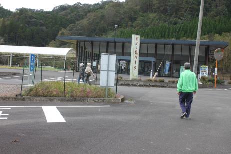 建物の前の駐車場に男女が3人が歩いている様子の写真