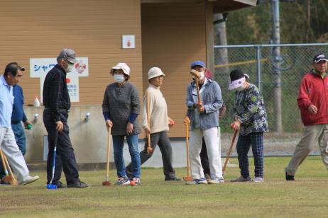 複数の男女がゴルフバットを持ってゴルフの準備をしている写真