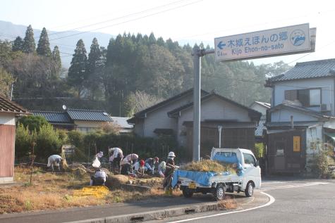 住宅の前で複数の男女が花壇の手入れをしている写真