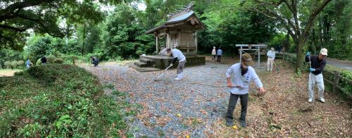 水分神社の境内を複数の方が熊手で清掃している様子の写真