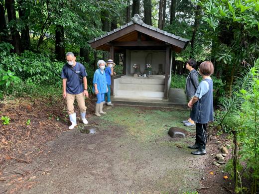 森の中にある神社で複数の男女が話をしている様子の写真