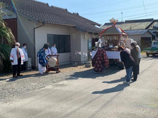 複数の男女が家の前で神事を行っている写真