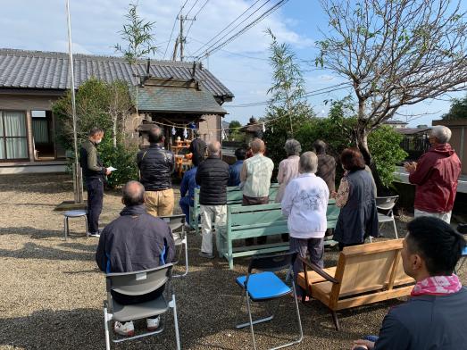 一人の男性が本尊に近づいて手前にいる住民の皆さんと一緒に祈りを捧げる様子の写真