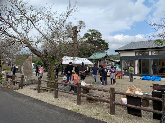 二階建ての建物の前にテントを張ってそのまわりに人だかりができてる様子の写真