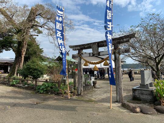 秋空の下鳥居の奥に人が複数立っている写真