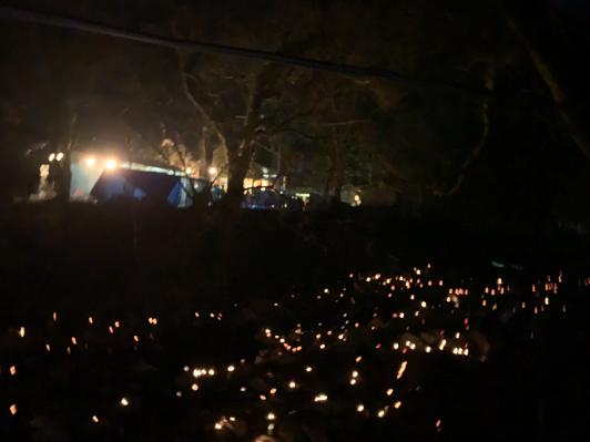 夜に行われた三地区神楽奉納の暗闇に無数のライトが点灯されている写真