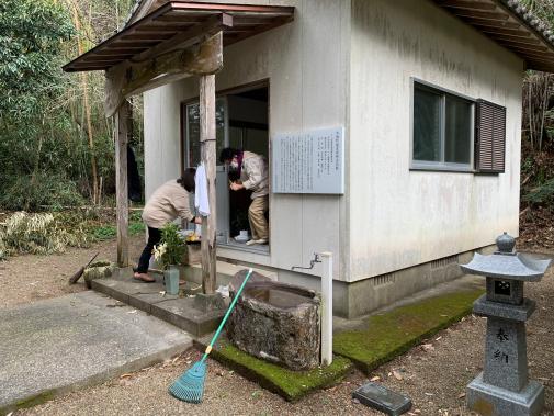 小屋の出入り口を掃除している女性たちの写真