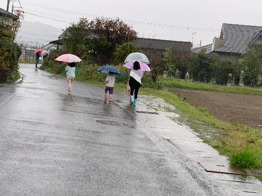 雨の中、傘を差した子供たち