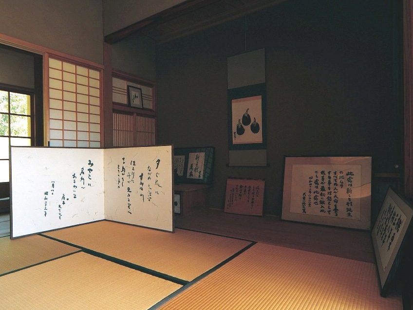 和室に掛け軸や屏風が多数置かれている武者小路実篤記念館内部の写真