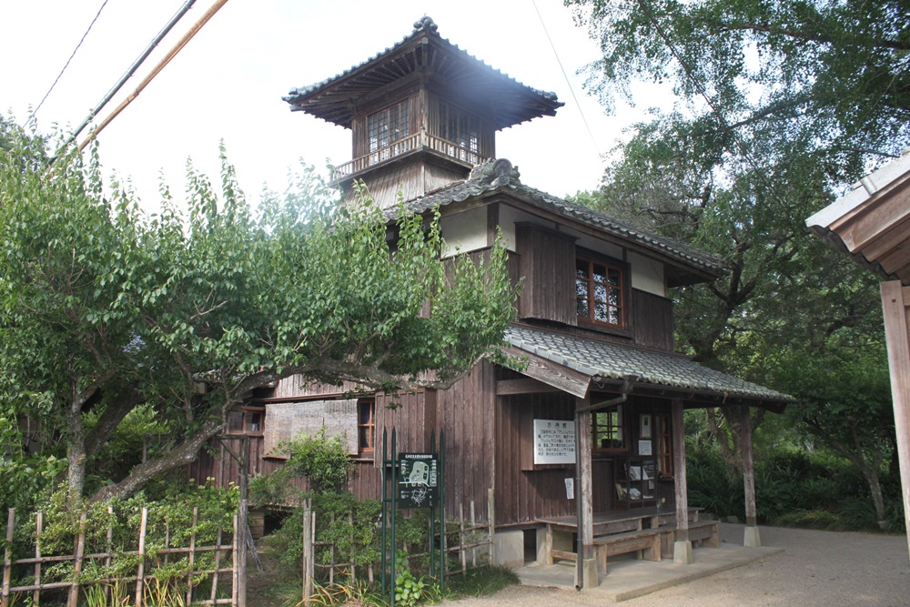 木が生い茂っている中に3階建ての木材でできた建物がそびえ建っている写真